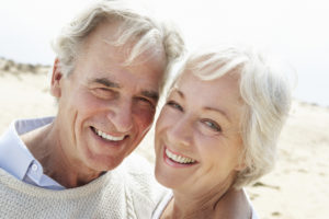 Senior Couple Walking Along Beach Together